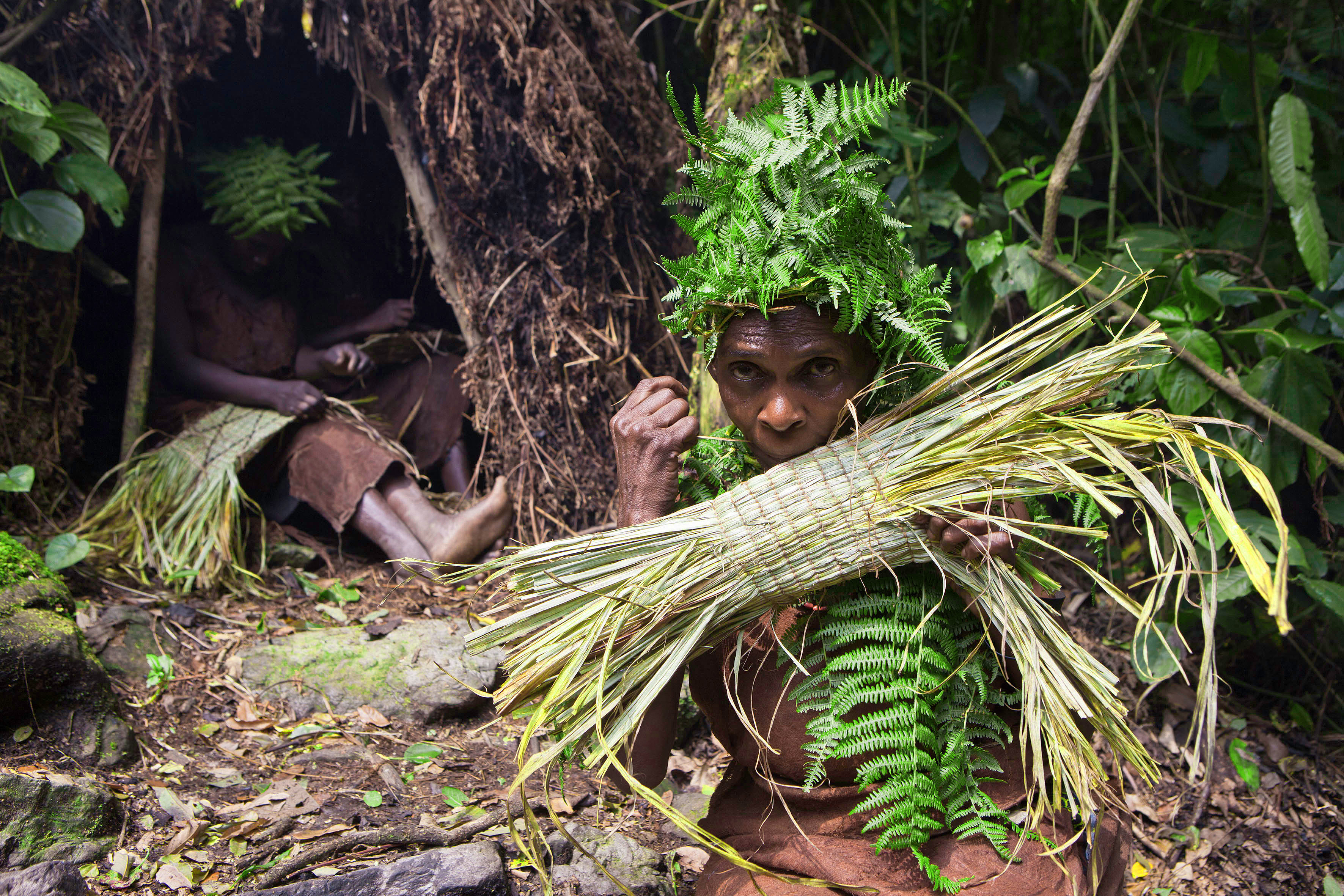 Femme Batwa tressant un panier