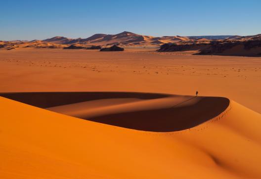 Trek dans un paysage de dunes rouges en Algérie