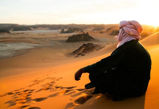 Trekking dans des dunes au soleil couchant dans la Tadrart en Algérie